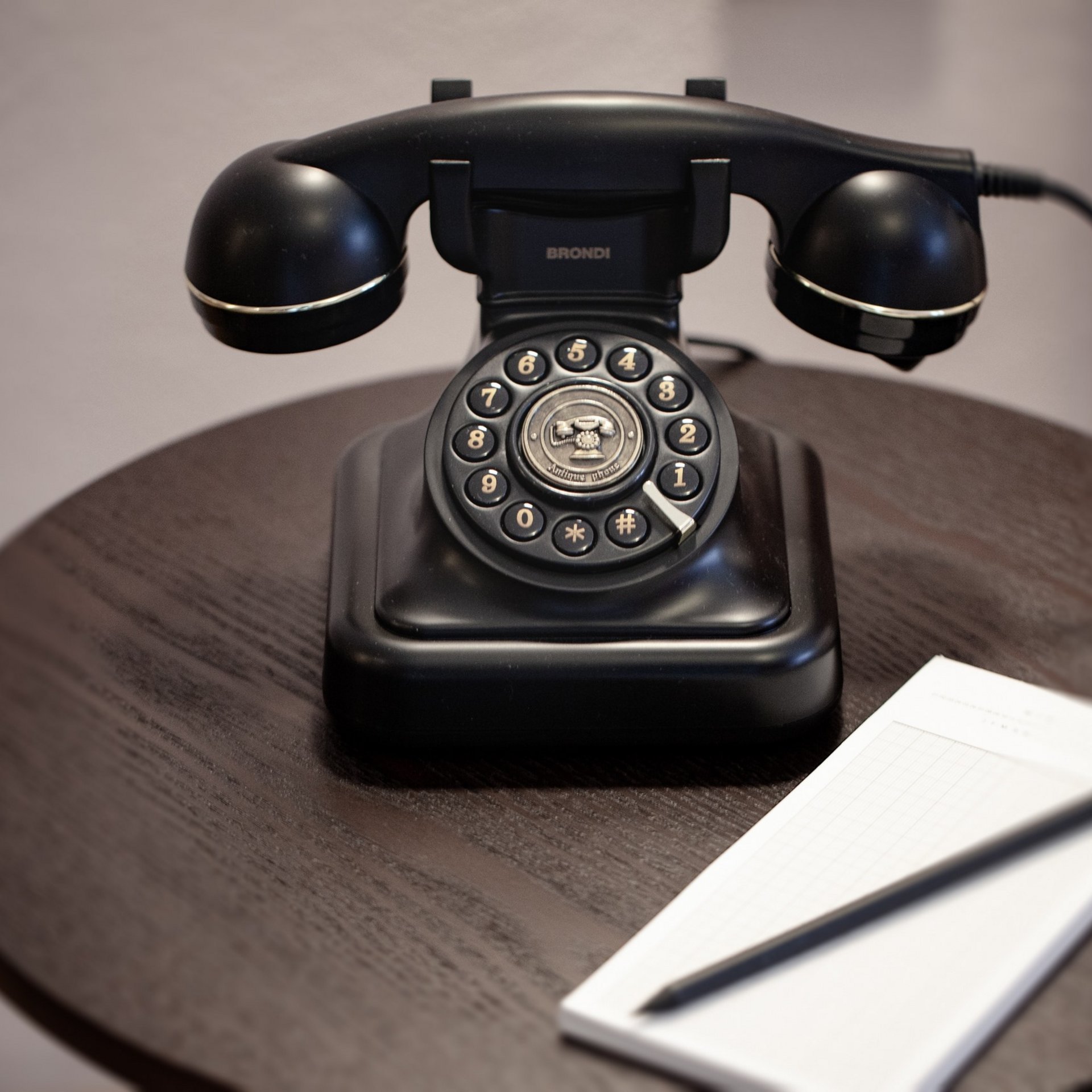 Nostalgisches Telefon Vintage-Telefon auf Holztisch mit Notizblock und Stift für klassischen Charme.